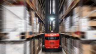 Ein Schmalgangstapler von Linde Material Handling im Einsatz in einer Lagerhalle.