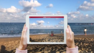 Projektion eines Flurförderzeugs an den Strand durch die Linde Showroom App von Linde Material Handling Die Linde Showroom App von Linde Material Handling projiziert auf dem Tablet ein Flurförderzeug an den Strand.