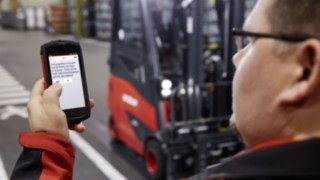 Pre-Optinal Ceck mit dem Smartphone Fahrer beim Vorabcheck des Fahrzeugs mit der Linde connect pre-opp App